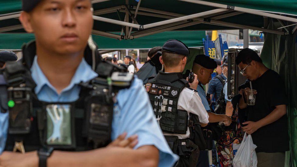 A man is stopped and searched by police officers at Causeway Bay near Victoria Park on June 04, 2023 in Hong Kong, China