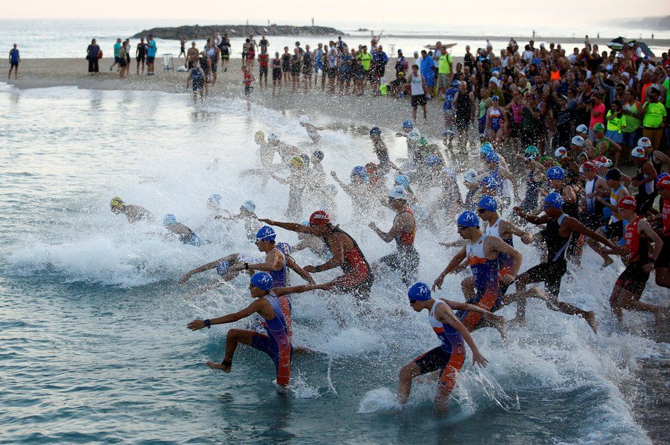 Participants rush into the water in the Mediterranean Sea as they take part in a triathlon in Ashkelon, Israel on June 16, 2017.
