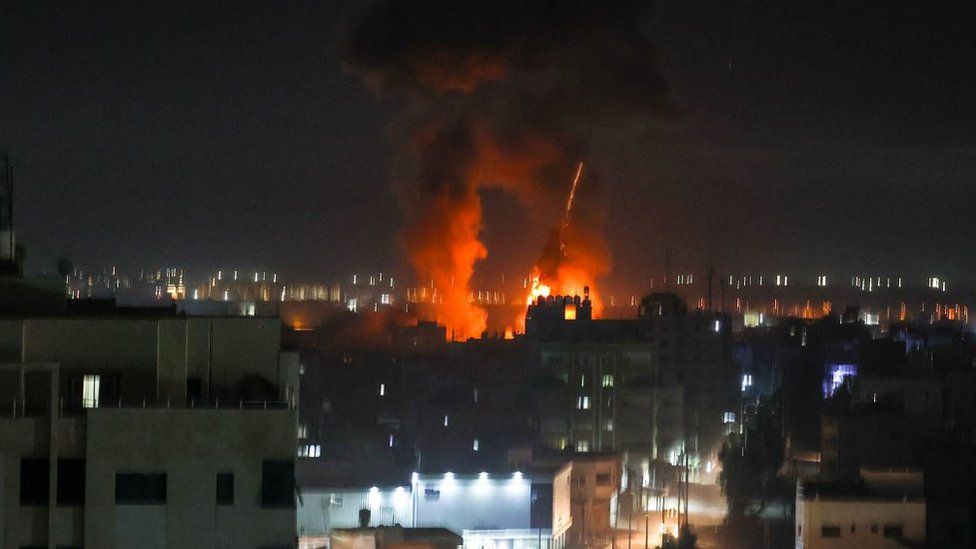 Explosions light-up the night sky above buildings in Gaza City as Israeli forces shell the Palestinian enclave