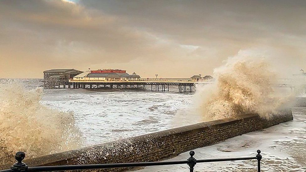 Waves crash over sea wall at Cromer in Norfolk