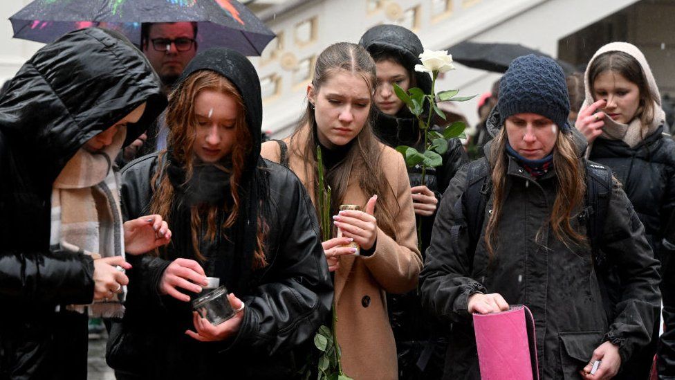 People light candles at a makeshift memorial for the victims outside the Charles University in central Prague, on December 22, 2023