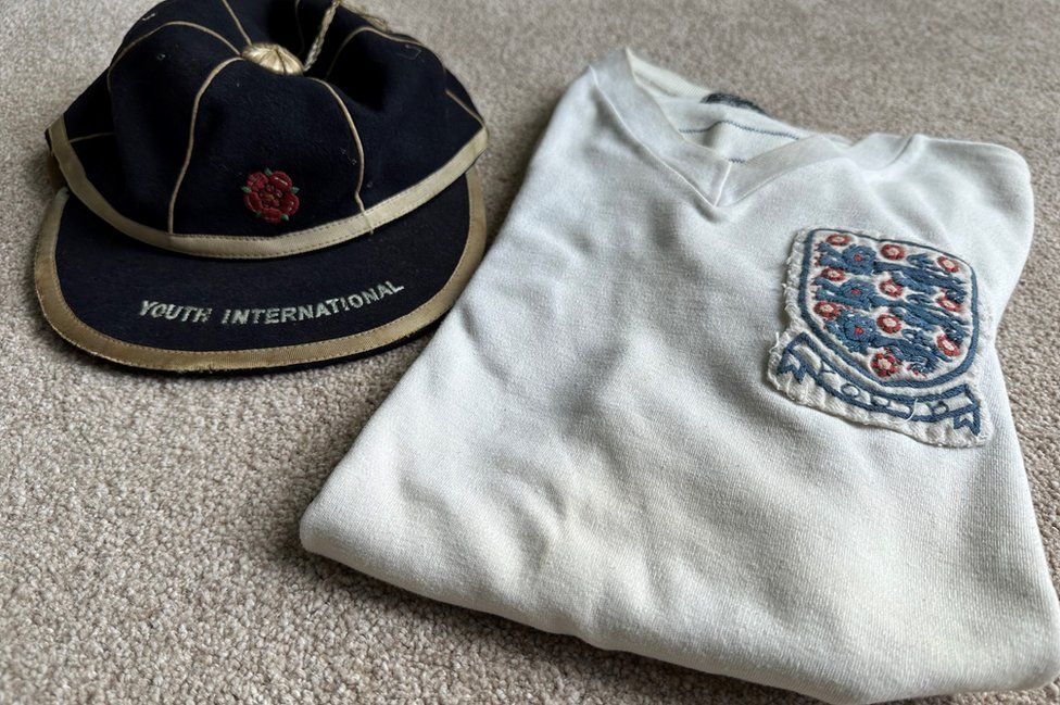 An old football cap and white England shirt