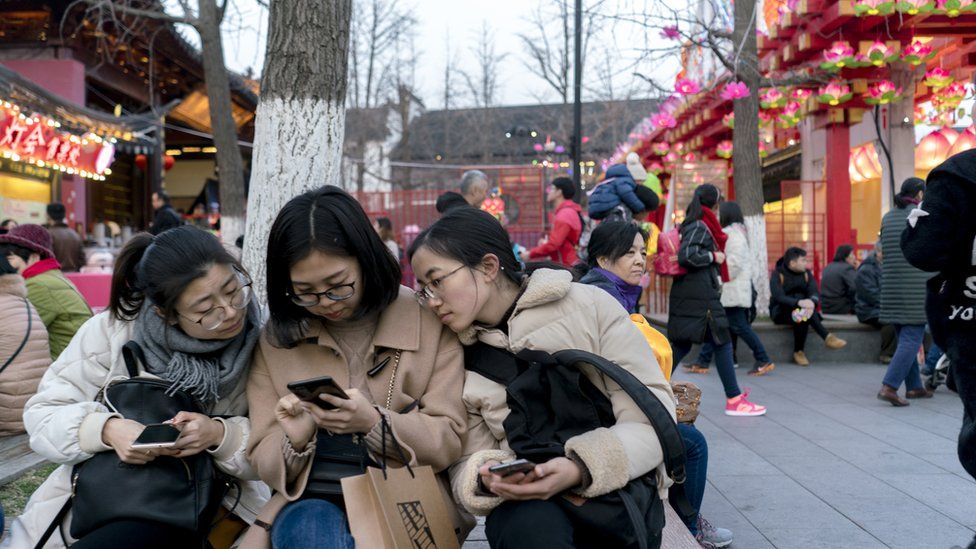 Women in China look at smartphones