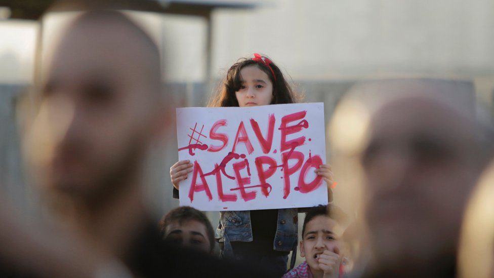 A girl holds up a placard saying "#Save Aleppo" at a protest in Tripoli, Lebanon (1 May 2016)