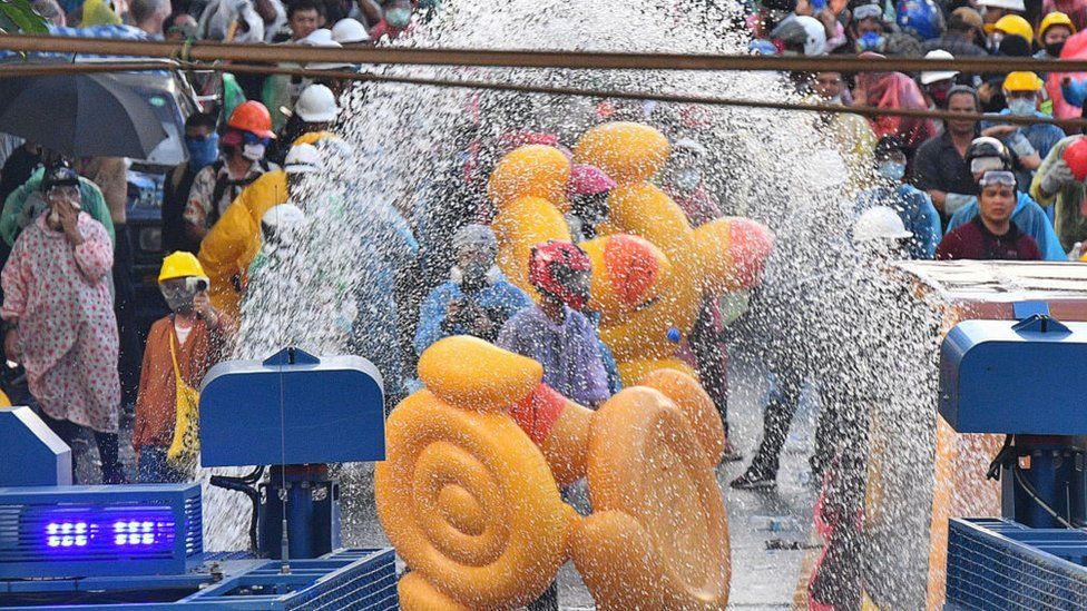 Demonstrators use inflatable rubber ducks as shields to protect themselves from water cannons during an anti-government protest in Bangkok, Thailand, 17 November 2020