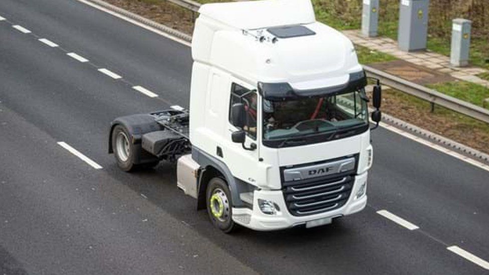 White HGV cab in lane 2 of a motorway, seen from a bridge