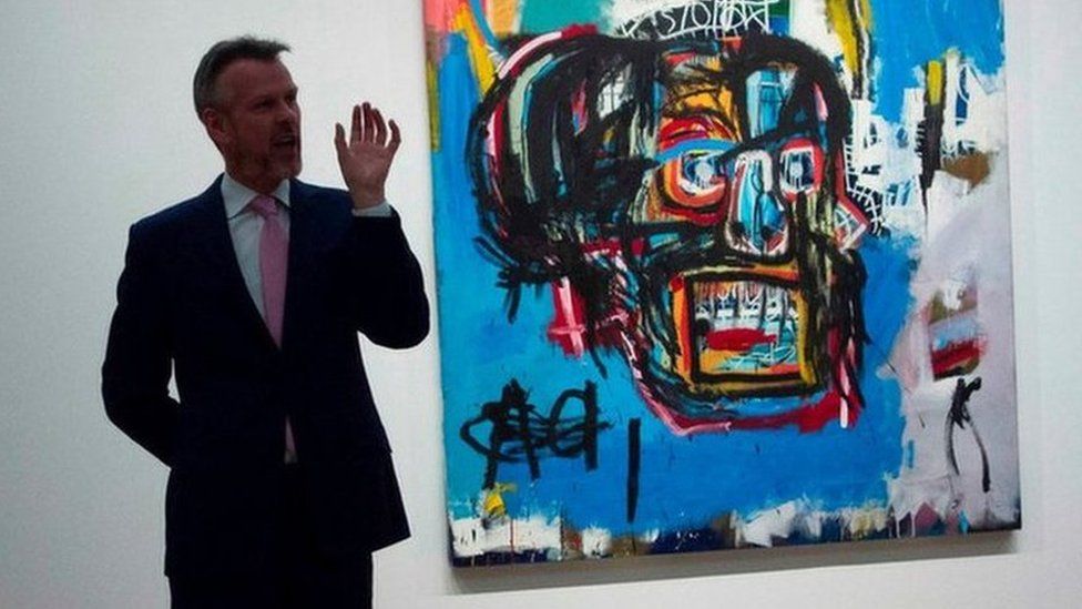 This file photo taken on May 5, 2017 shows a Sotheby's official speaking about Untitled, a 1982 painting by Jean-Michel Basquiat during a media preview at Sotheby's in New York.