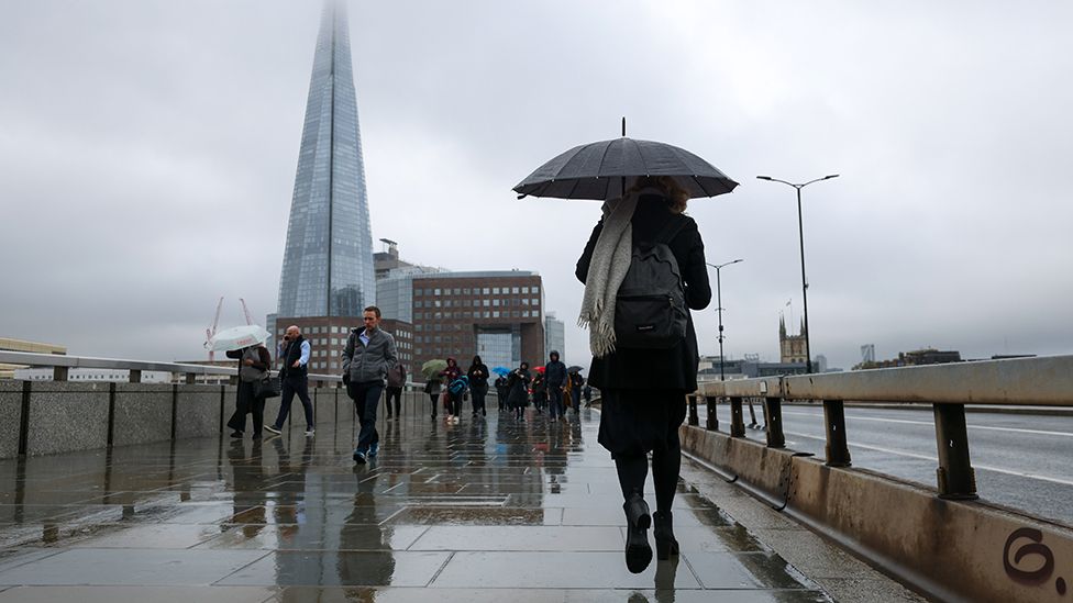 Commuters cross London Bridge, during Storm Ciaran, in view of The Shard skyscraper in London, UK, on Thursday, Nov. 2, 2023