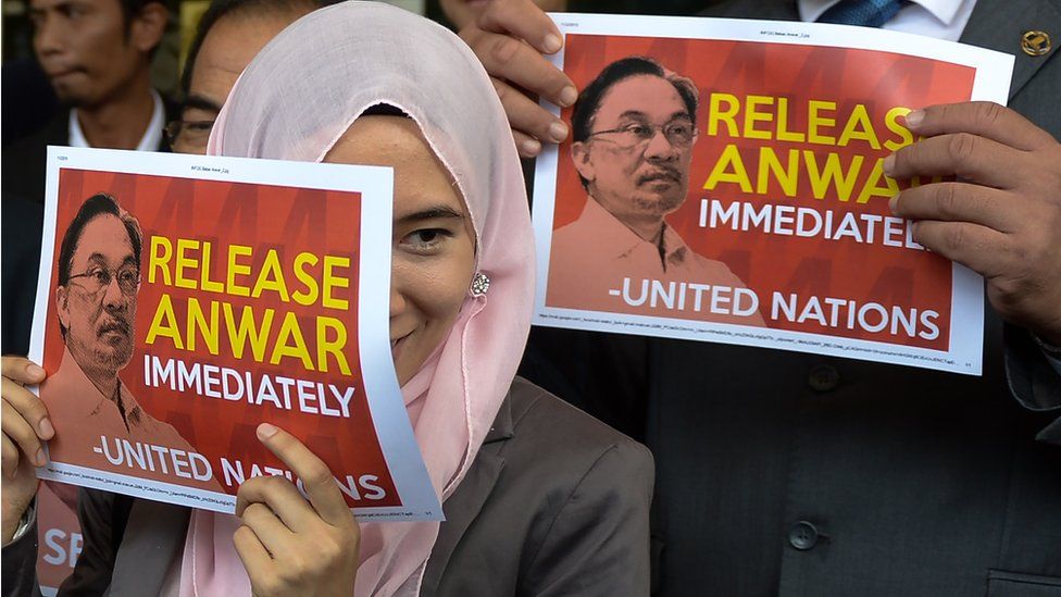 Members of the Malaysian opposition parties hold signs reading 'Release Anwar immediately' in Kuala Lumpur in 2015
