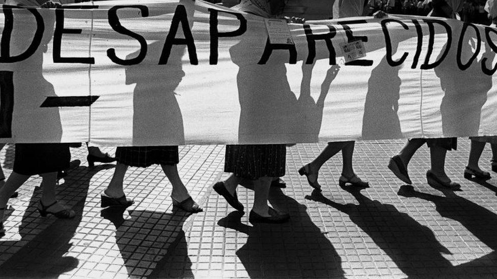 Members of the "Madres de Plaza de Mayo" human rights organization, hold a banner claiming for their missing sons and daughters as they walk in front of the Presidential Palace, circa 1980 in Buenos Aires.