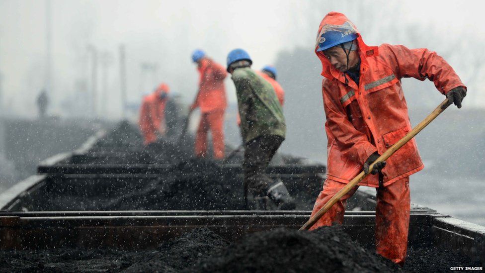 Workers load coal onto railcars at a railway station in Jiujiang, China