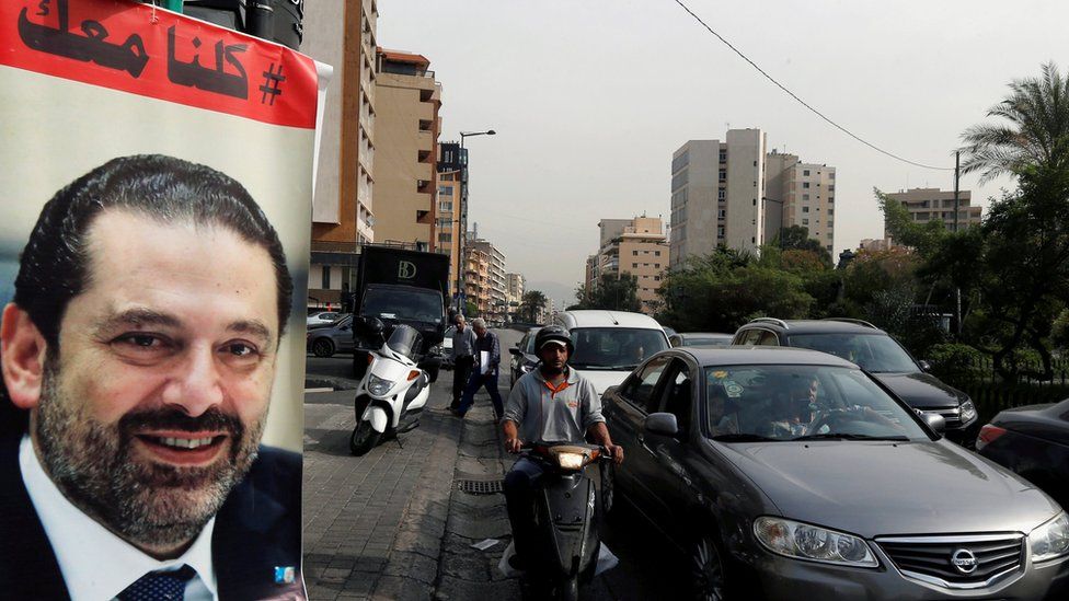 Cars pass next to a poster showing Saad Hariri and saying "All of us are with you" in Beirut, Lebanon (13 November 2017)