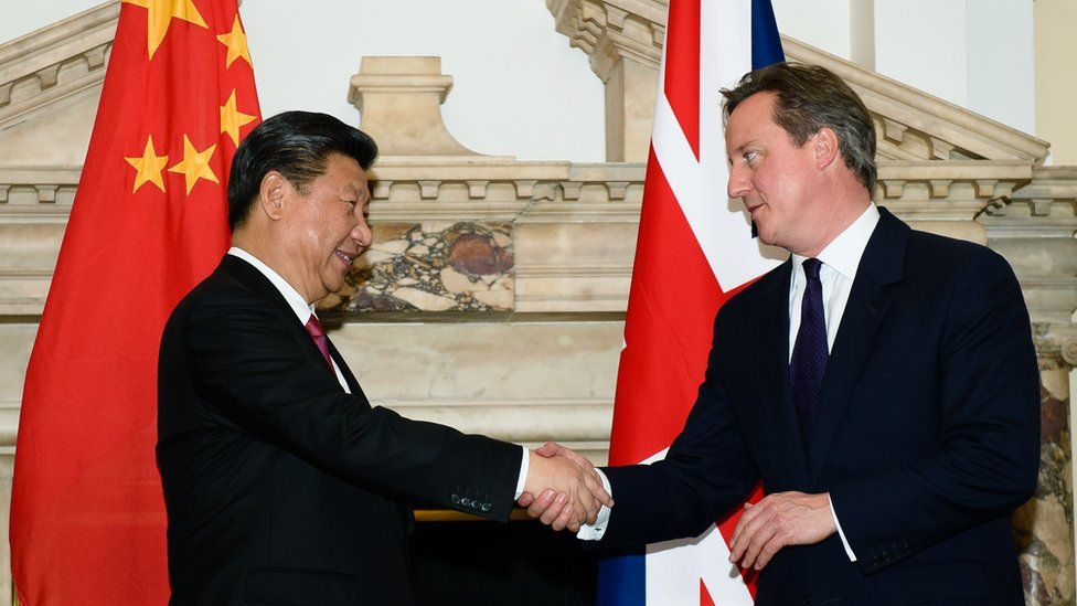 China's Xi Jinping shakes hands with David Cameron