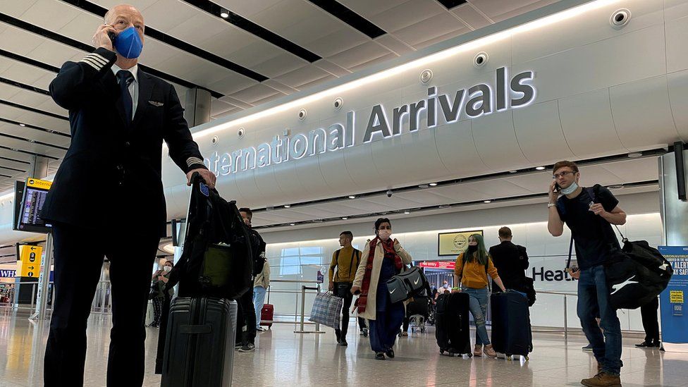 A member of aircrew is seen wearing a protective face mask at Heathrow Airport