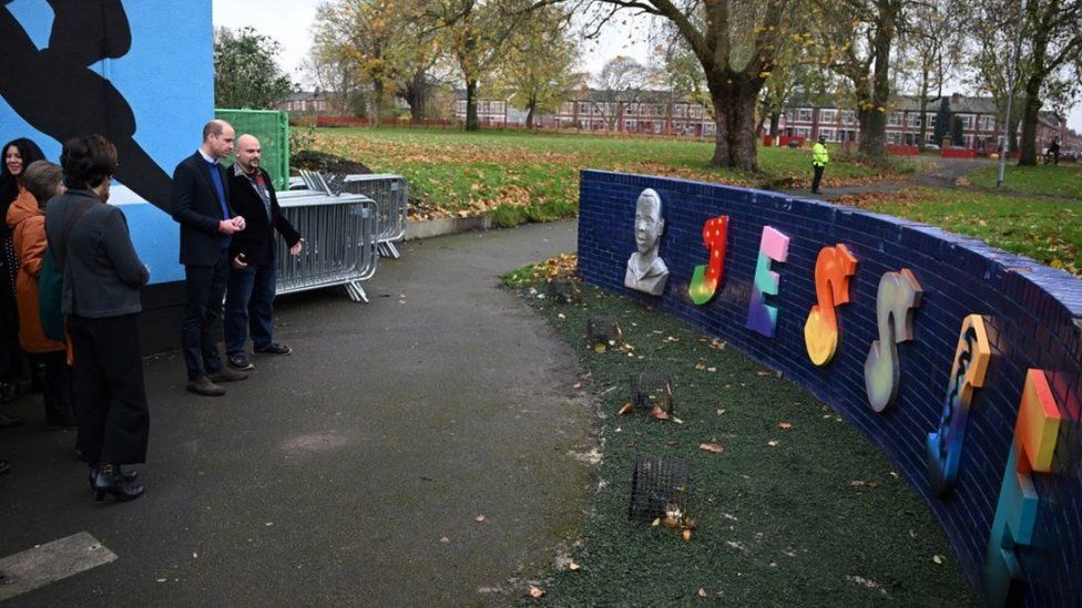 The Prince of Wales looks at Jessie's Wall, a memorial built in tribute of Jessie James, a teenager shot dead in 2006 in a park in Moss Side,