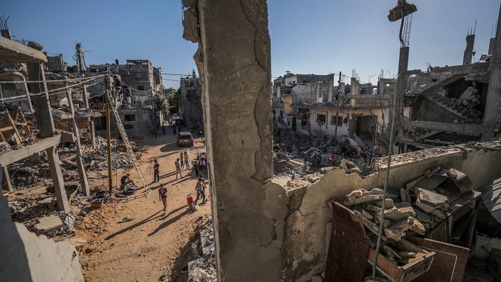 Palestinians inspect their destroyed houses in Gaza