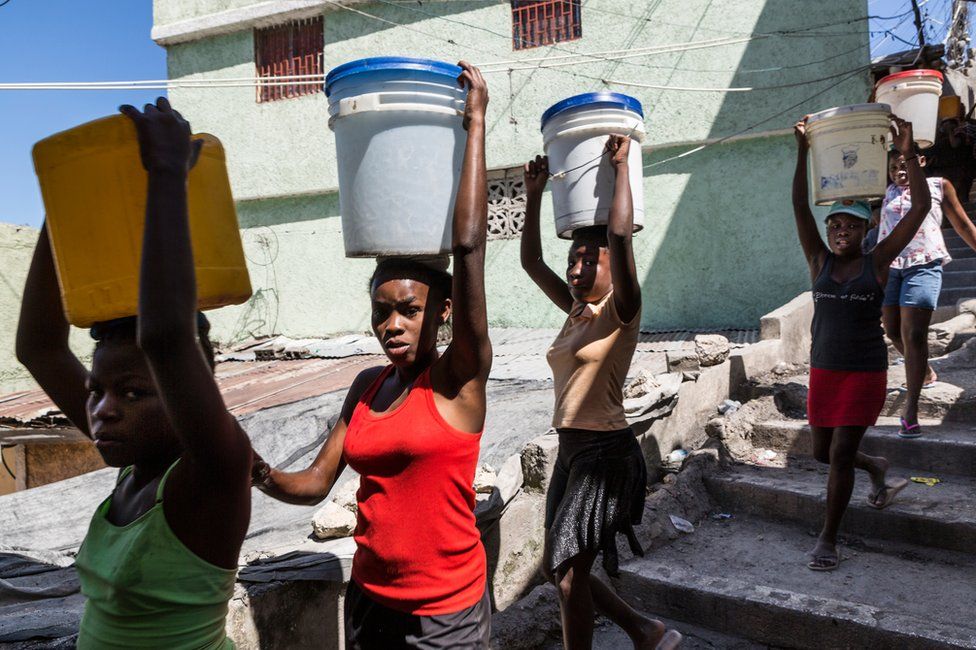 Молодые девушки переносят воду с главной станции подачи воды обратно в свои дома