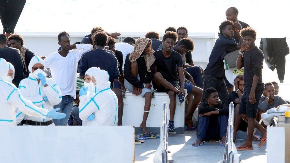 Migrants wait to disembark from the Italian coast guard vessel Diciotti at the port of Catania, Italy, August 22, 2018