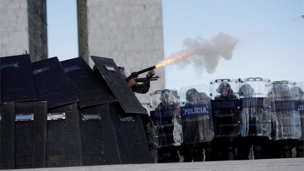 Riot police fire tear gas toward brazilian Indians during a demonstration against the violation of indigenous people"s rights, in Brasilia, Brazil April 25, 2017