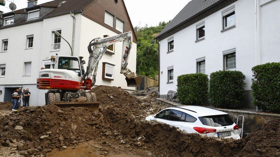 A digger clears debris in Germany after flooding, 15 July 2021