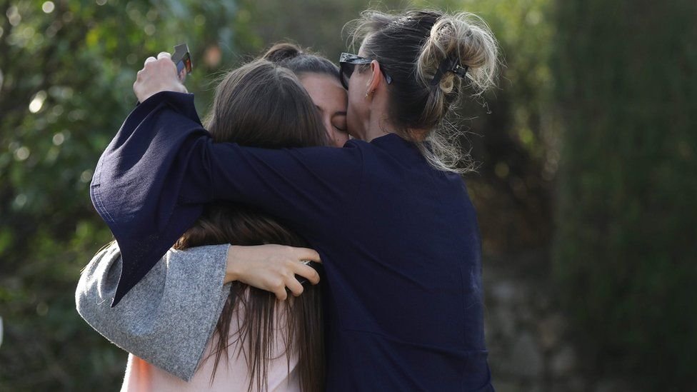 People react near the Tocqueville high school in the southern French town of Grasse, on March 16, 2017 following a shooting that left two people injured