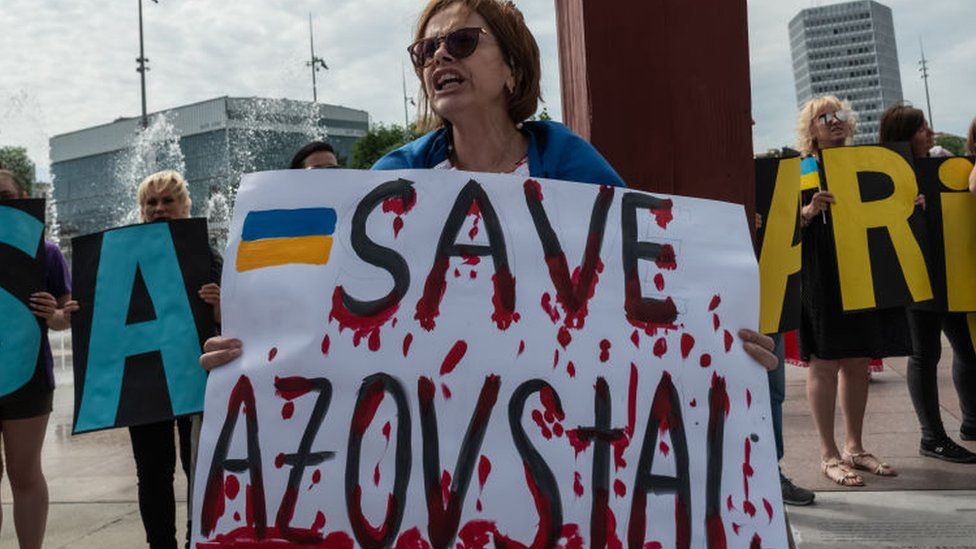 A protester holds a sign reading Save Azovstal