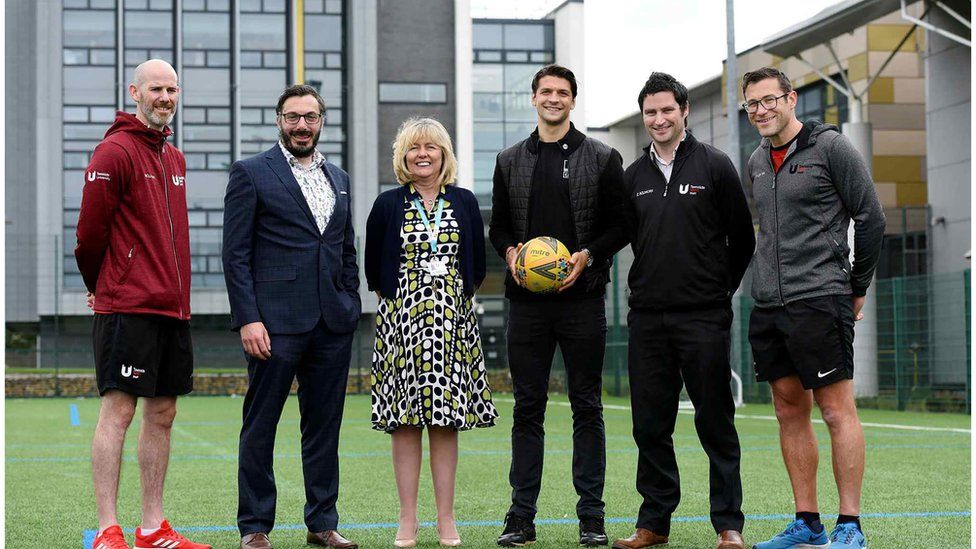 University staff involved in the academy with footballer George Friend (holding the ball)