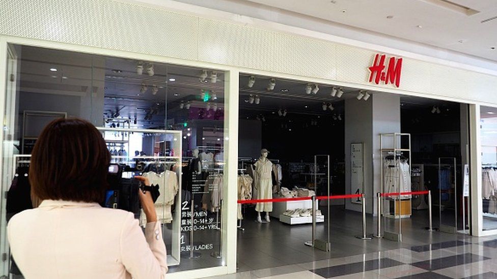 Люди проходят мимо закрытого магазина H&M в Цзинане, провинция Шаньдун, Китай