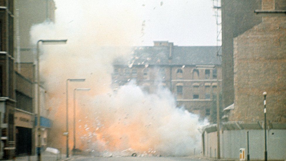 A colour image of a bomb exploding in a street in Northern Ireland during the Troubles