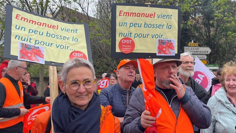 Protesters, wearing CFDT labour union vests, attend a demonstration against pension law before the arrival of French President Emmanuel Macron in Muttersholtz, Eastern France, April 19, 2023