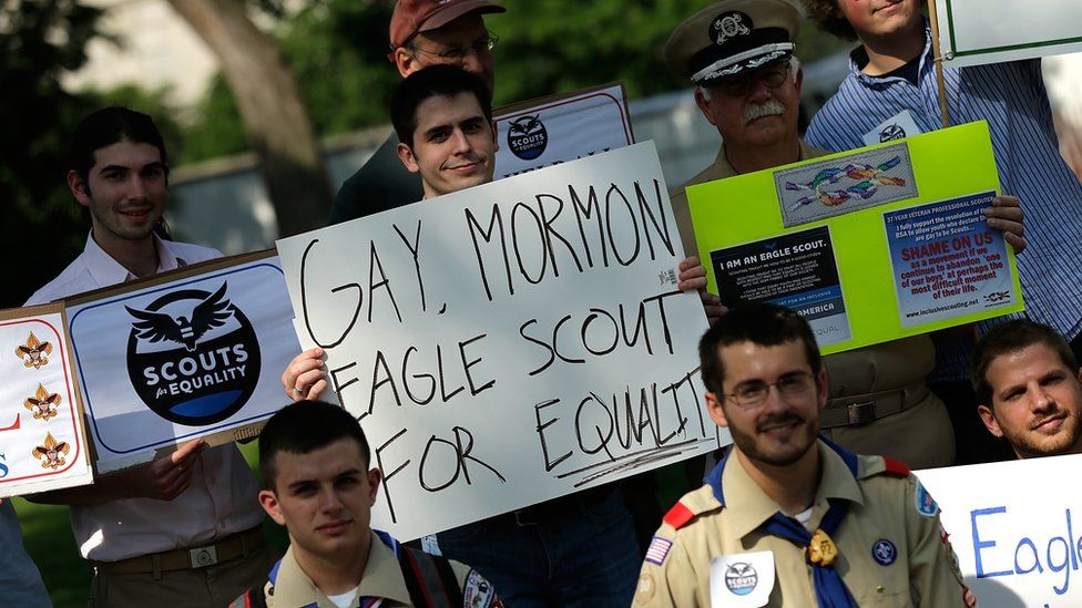 Boy holds sign reading 'Gay, Mormon, Eagle Scout for Equality'