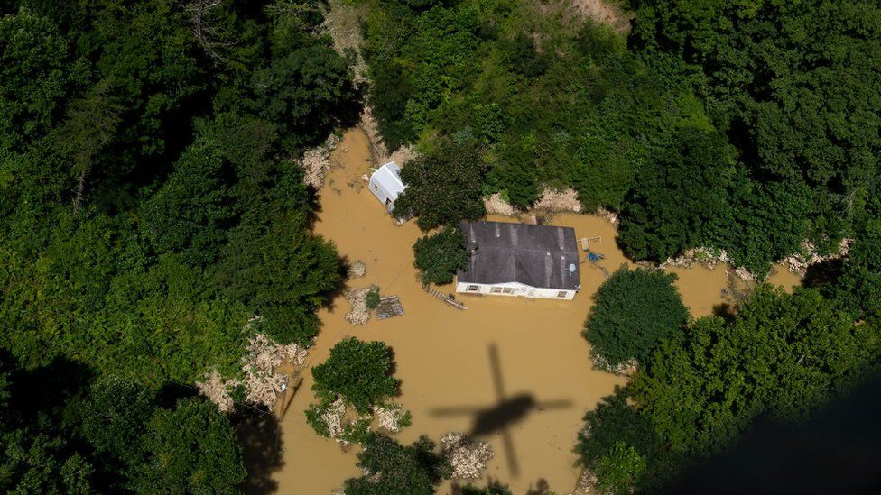 Image shows a home stranded by floodwaters