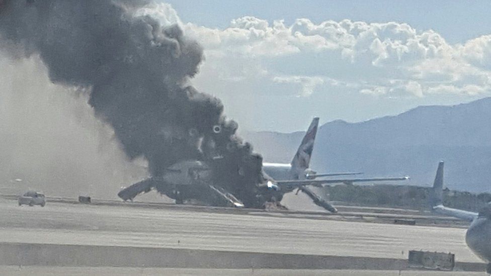 The view of a plane window, smoke billows out from a plane that caught fire at McCarren International Airport, 8 September 2015