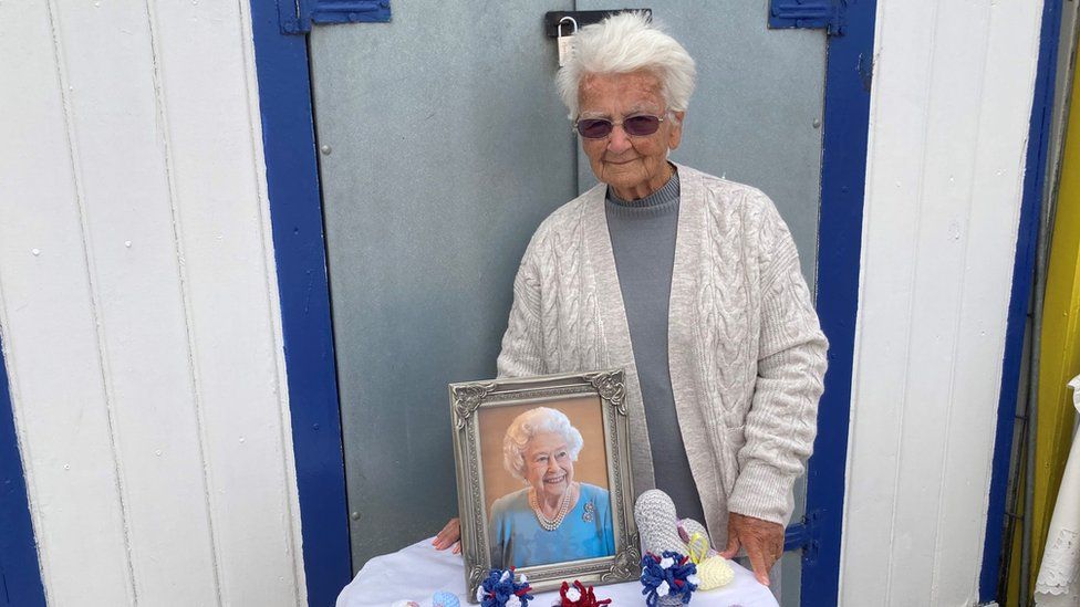 Margaret Seaman standing by a beach hut