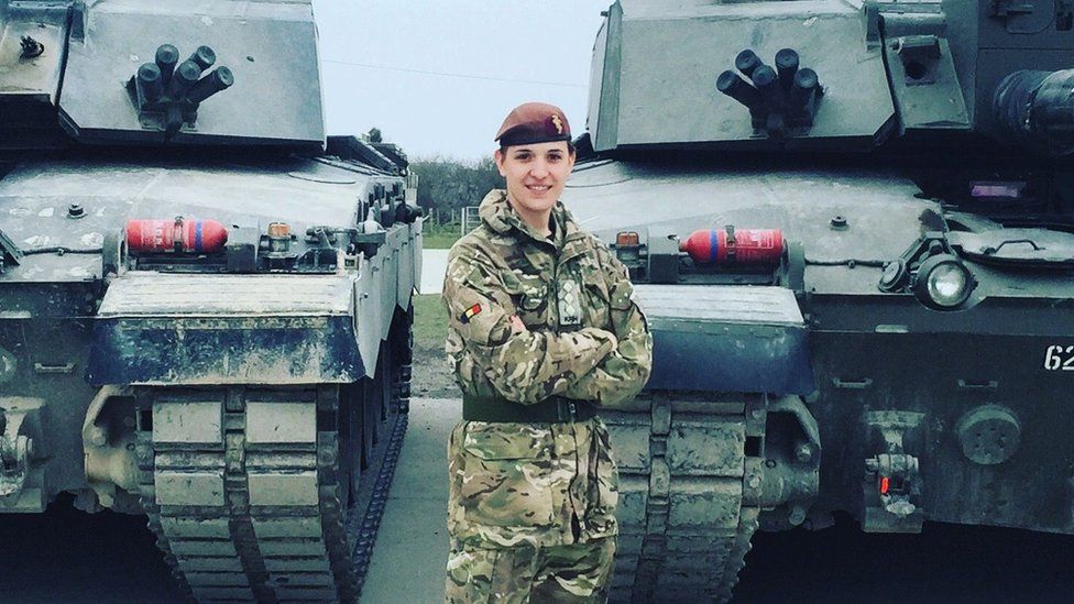 Hannah Graf in uniform in front of tanks