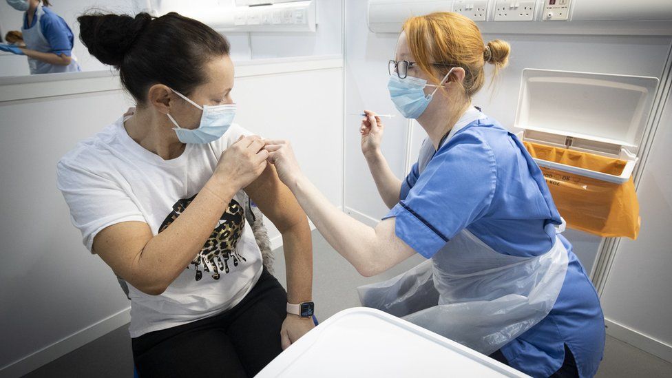 A Nurse administers a coronavirus vaccine to a patient