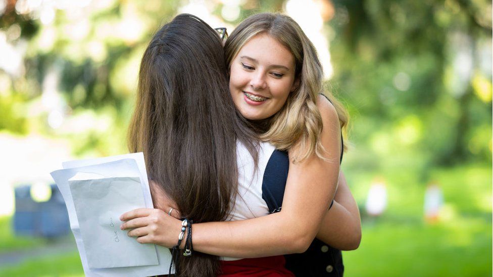 Chloe Orrin hugs a friend after opening her GCSE results at Ffynone House school on August 20, 2020 in Swansea, Wales