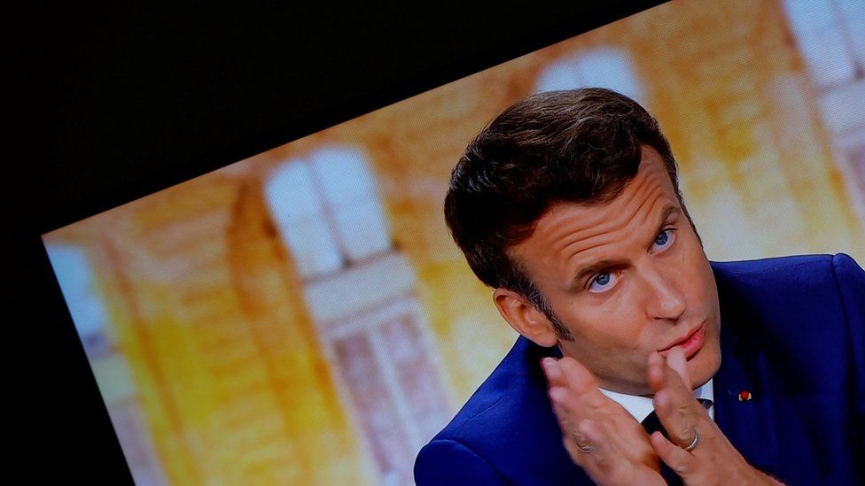 Emmanuel Macron gestures in this still image of a television displaying the debate feed