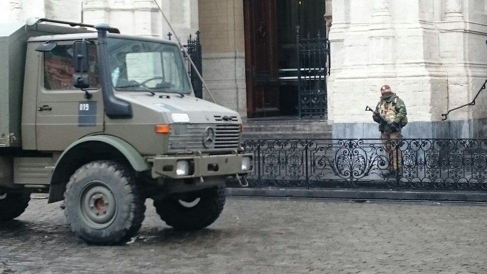 An army truck and a soldier on a Brussels street