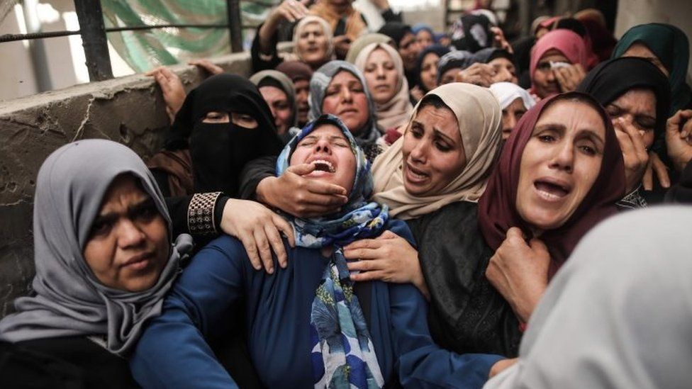 Palestinian relatives of Hamdan Abu Amsha cry during his funeral in Beit Hanun in the northern of Gaza Strip