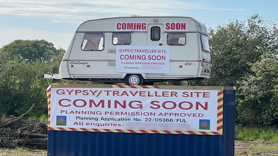 A caravan has been erected on top of a shipping container to advertise the site