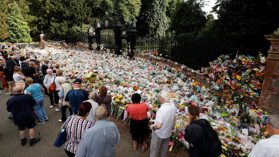 People look at floral tributes at the Sandringham Estate, following the death of Britain's Queen Elizabeth