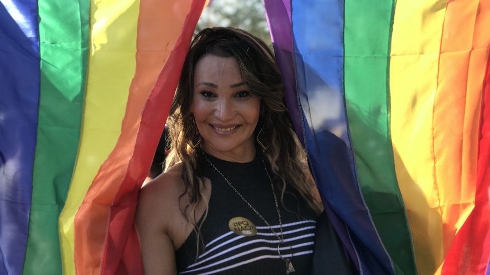 Tiffany Abreu poses for a photo in front of a rainbow flag