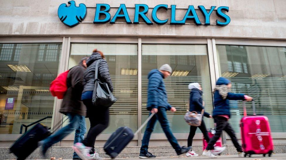 Pedestrians walk past a branch of Barclays bank in central London