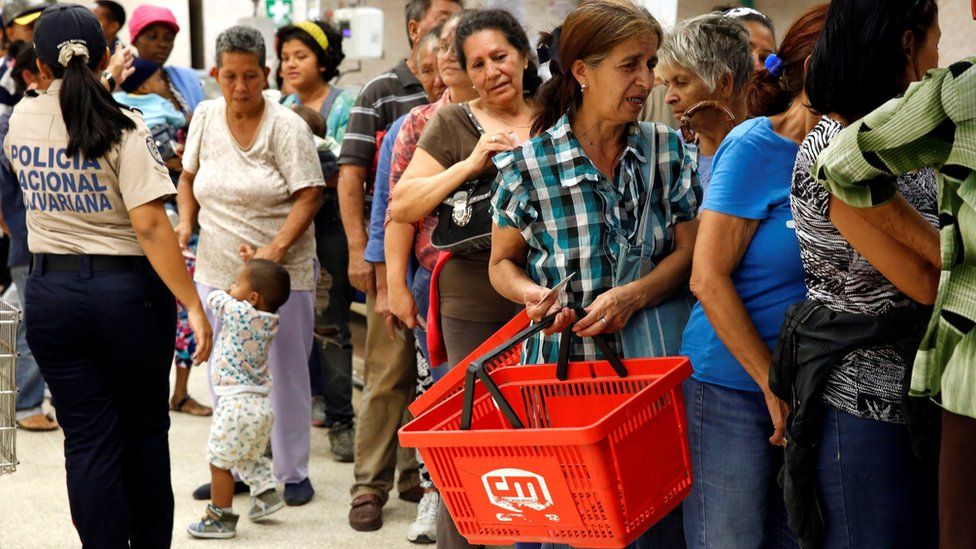 People line up to buy food and other staple goods inside a supermarket in Caracas, Venezuela on 30 June