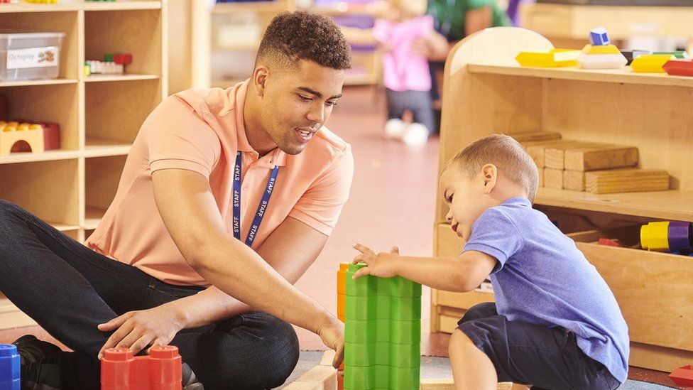 A child plays with a staff member at a nursery