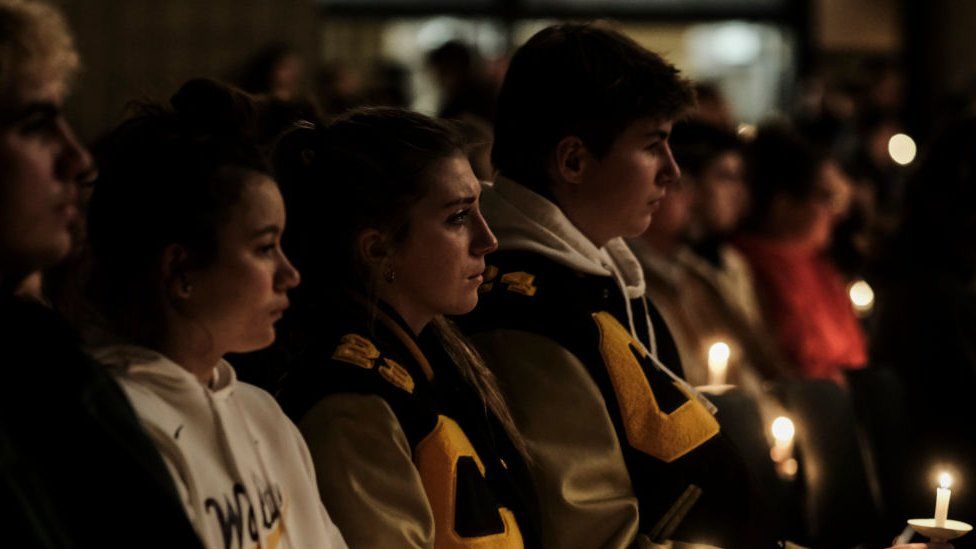 Students, parents, teachers, and community members gather for a vigil at the Lake Point Community Church