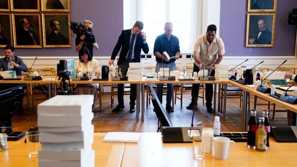 Members of the Danish Committee of Inquiry receive the report investigating the government's decision to cull all of its minks at the Danish Parliament in Copenhagen on 30 June
