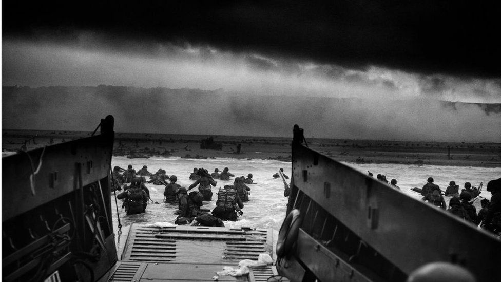 Photograph of U.S Troops rushing to the Normandy Beaches in France during the D-Day landing. Dated 1944.