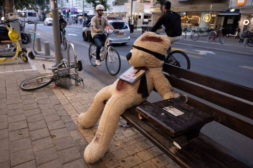 A blindfolded teddy bear, used to raise awareness about the child hostages held by Hamas, is set on a bench on December 26, 2023 in Tel Aviv, Israel.